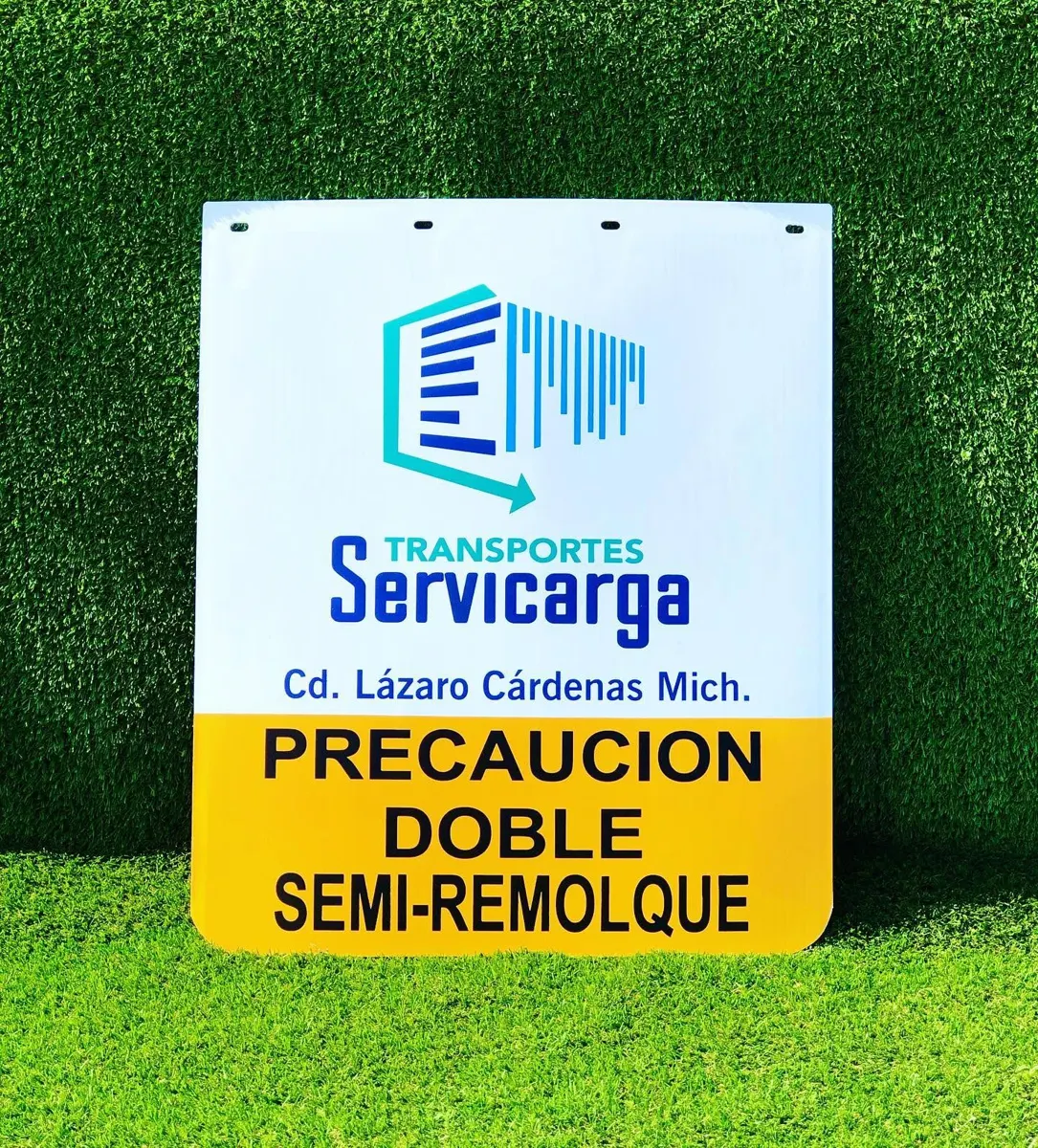 Lodera blanca con logotipo de transportes y leyenda Precaución doble semirremolque en franja amarilla