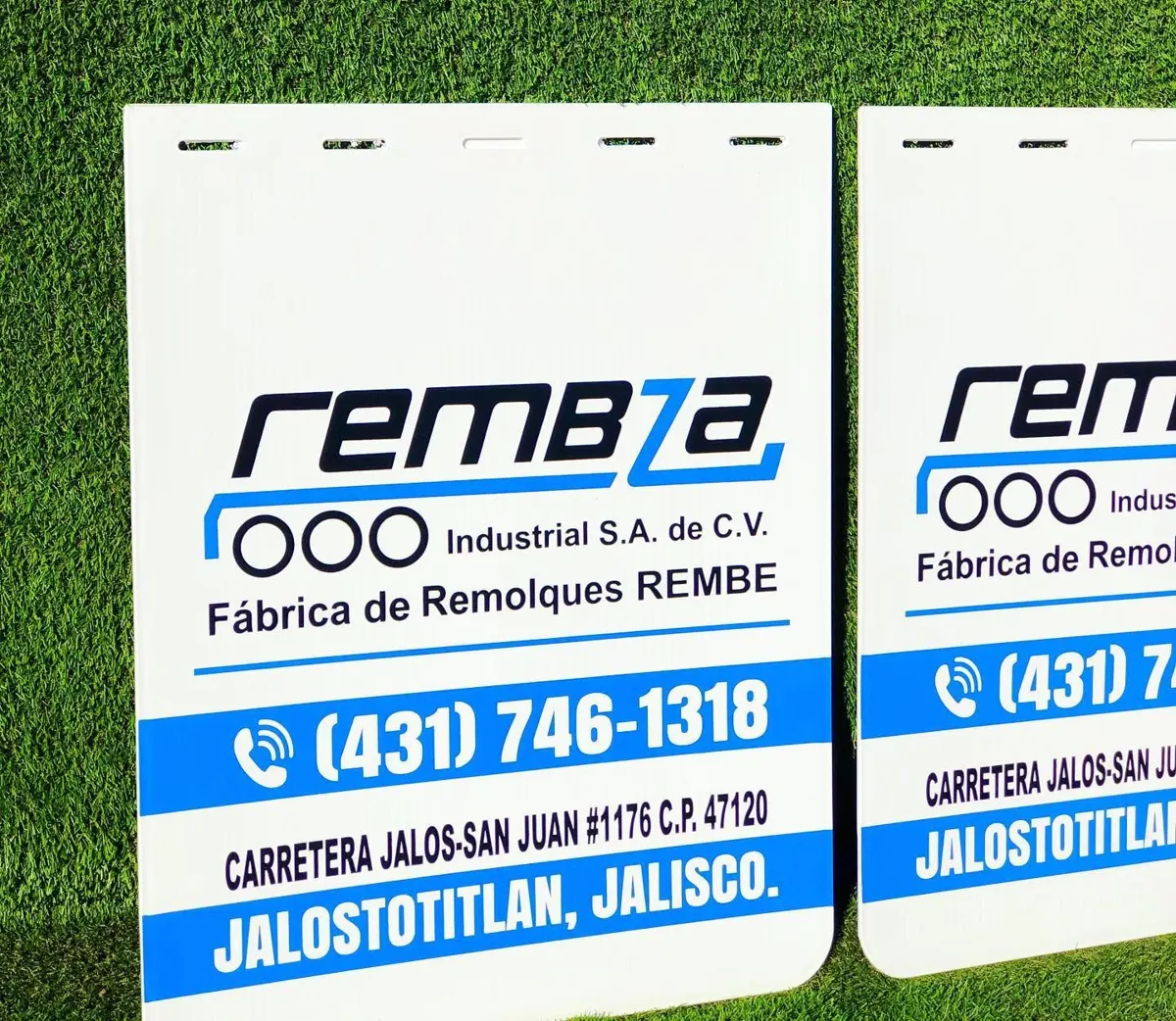 Loderas blancas de fábrica de remolques con logotipo azul, teléfono y dirección