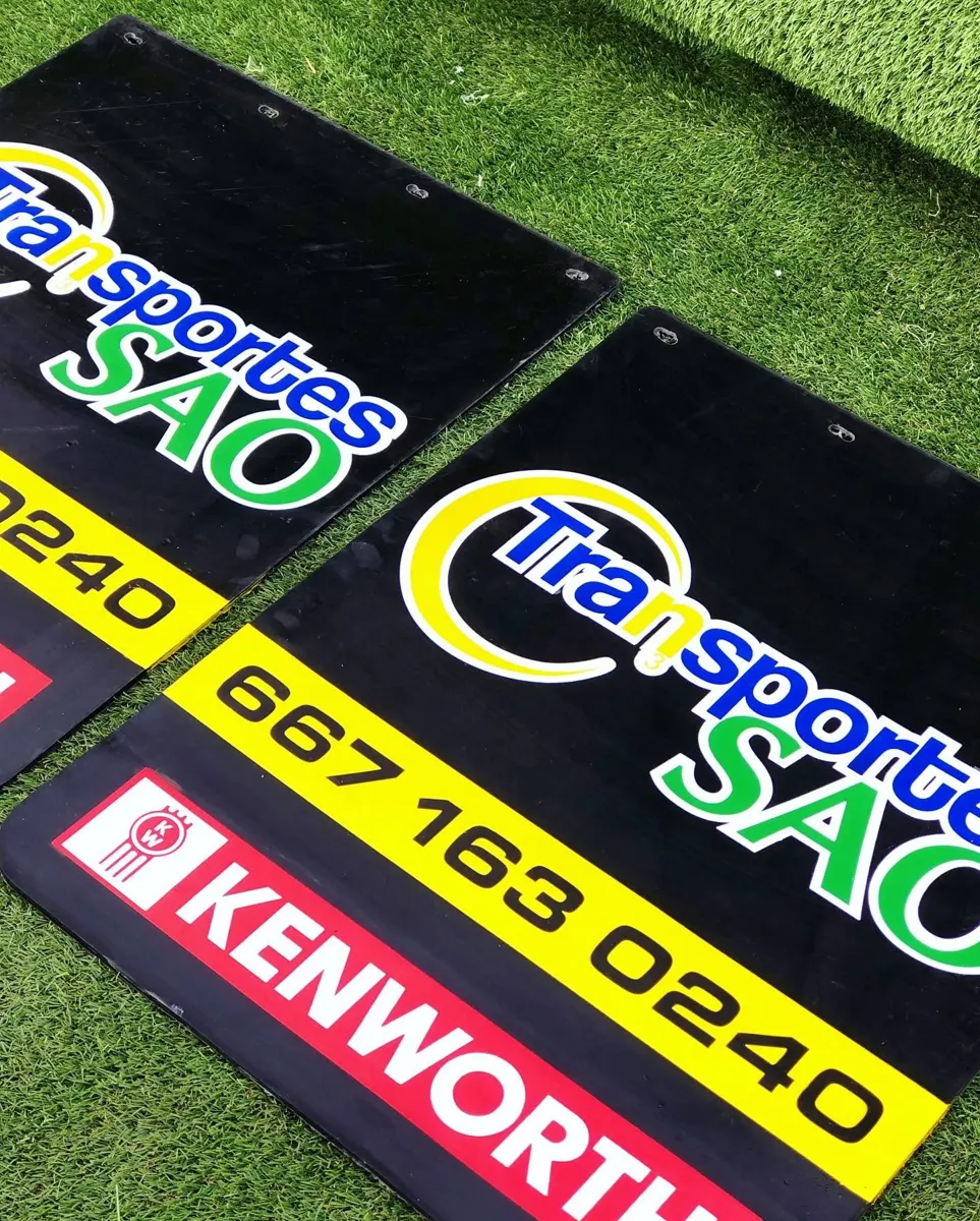 Loderas negras con logotipo amarillo de transportes y teléfono en letras grandes